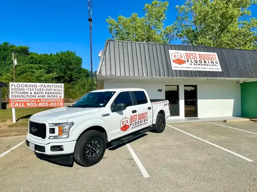 The Best Budget Flooring & Remodeling showroom on FM 2493 with the lettered company pickup out front