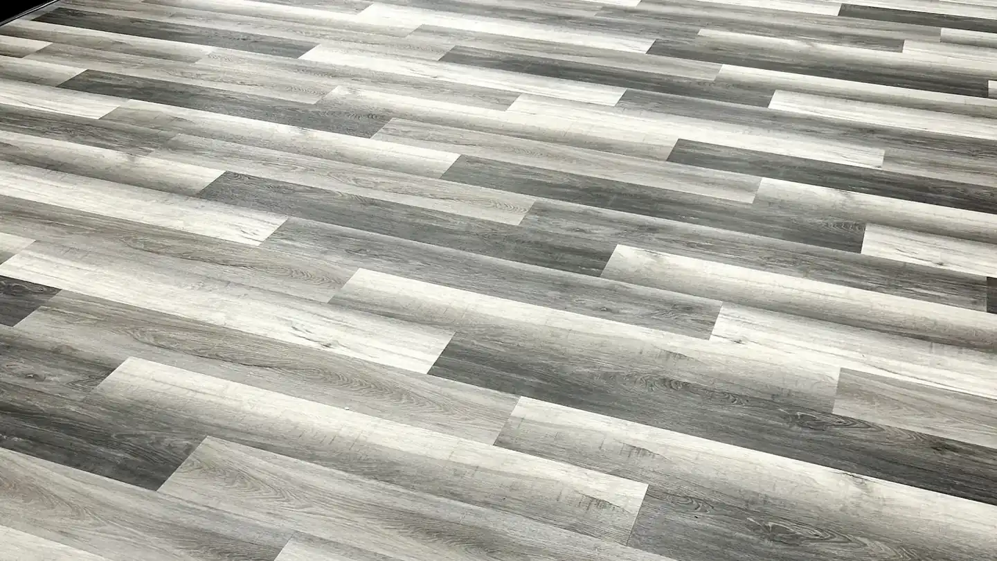 Grey vinyl plank floor laid on a diagonal through an open room