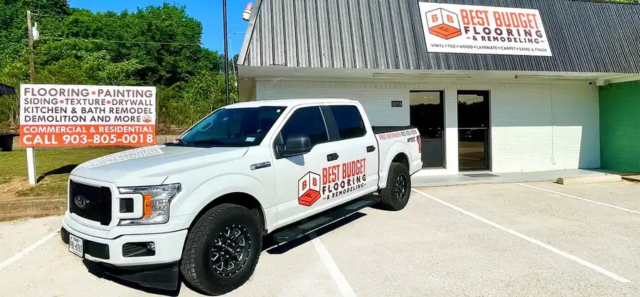 Wide view of the showroom building, its roadside sign and the lettered white pickup truck on Old Jacksonville Hwy